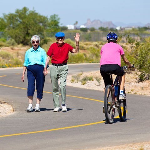 A couple wave at a bike rider on The Loop